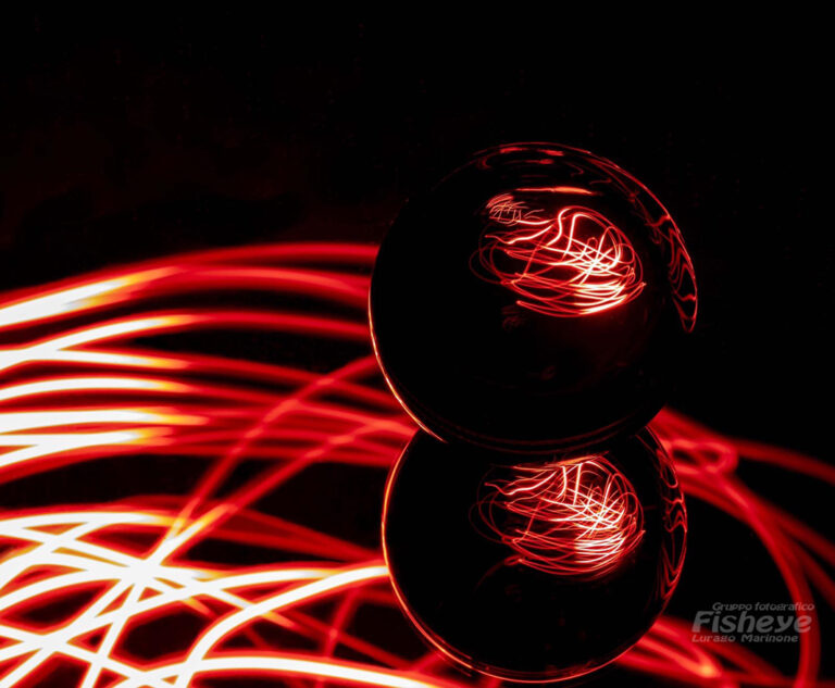 gioco di luci intorno a una sfera, toni di rosso